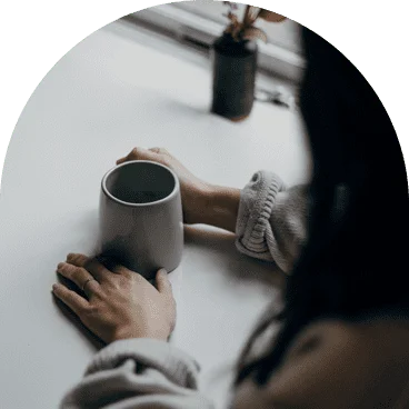 an over-the-shoulder camera shot of a woman holding a coffee cup