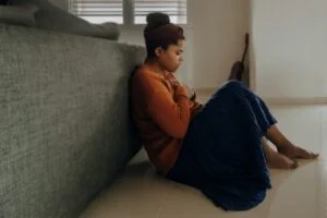 Worried woman sitting on floor